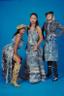 models in denim-textile garments and patterned boots against a bright blue background