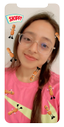 girl wearing glasses and a pink shirt is playfully surrounded by peanuts