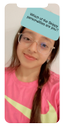 girl in a pink shirt and glasses displaying a sticker