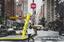 woman walks along the street, showcasing a large yellow pen