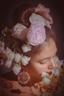 woman with elaborate floral headdress and earrings, close-up